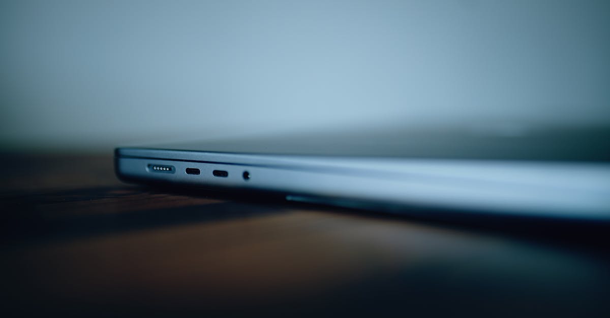 Blurred close-up of a laptop's edge resting on a wooden table.